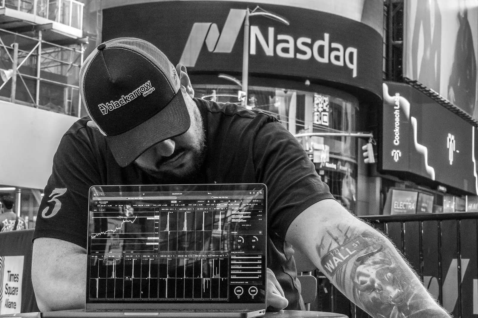 Rafael Schroeder concentrado no gráfico, em preto e branco, em frente à Nasdaq